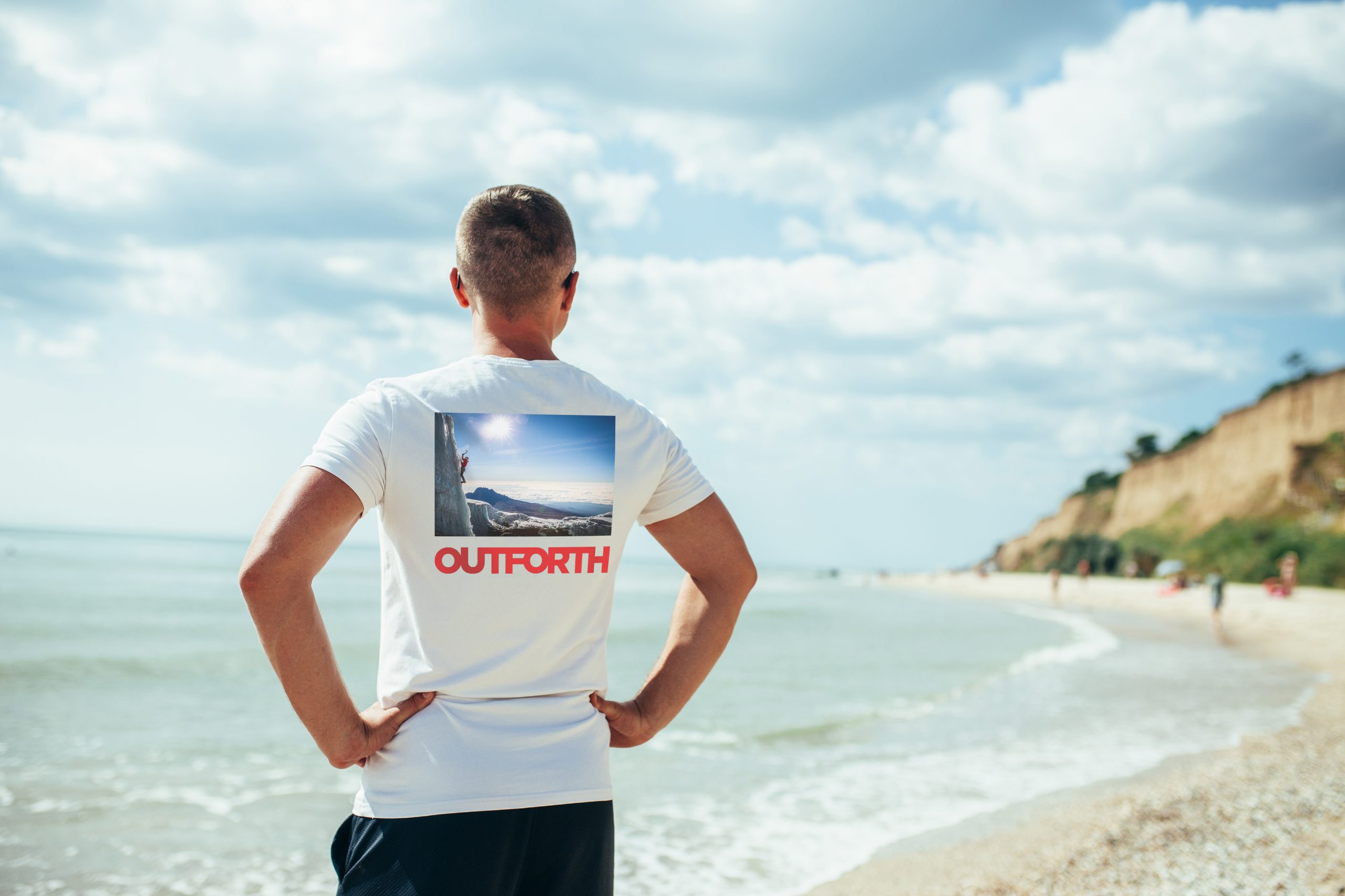 Young man in white t-shirt and sunglasses at the tropical beach. Mock-up for print. T-shirt template.
